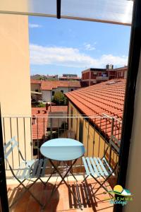 d'un balcon avec deux chaises et une table. dans l'établissement Maremma Holidays -Residenza Olesià, à Follonica