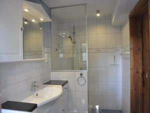 a white bathroom with a sink and a shower at Hof Tummetott in Mittelangeln