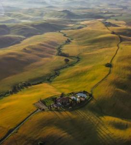 widok z powietrza na dom w środku pola w obiekcie AGRITURISMO LUCERTOLA w mieście Montecatini Val di Cecina