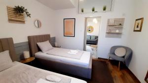 een kleine kamer met 2 bedden en een stoel bij Apartment Eleco in Bjelovar