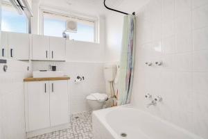 Un baño blanco con lavabo e inodoro. en Sweet 1BR Studio In St Kilda, en Melbourne 3 fotos más