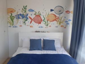 - une chambre avec un lit avec des poissons sur le mur dans l'établissement Apartamenty Pisakowe - Apartament Śledzik, à Rowy
