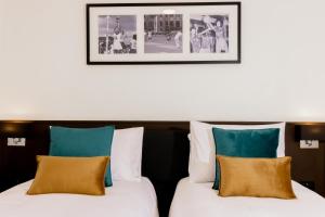 duas camas num quarto de hotel com uma fotografia na parede em Capricorn Hotel Suva em Suva