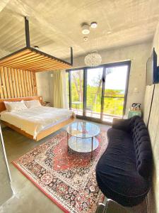Stäy Hotel في ناغُو: غرفة نوم بسرير واريكة وطاولة زجاجية