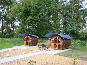 two small tents in a park with chairs and tables at Schlaffass bei Meyerhöms in Hermannsburg