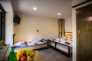 Ubytovacie zariadenie U Mudajov في Kraľovany: غرفة بسريرين و صحن فاكهة