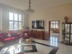 sala de estar con sofá rojo y TV en Luxus Ferienwohnung/Suite in Villa D' Aragon en Gera