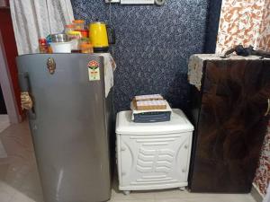 a refrigerator next to a trash can with a box on it at Kaveri home stays in Guwahati