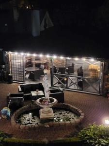 una fuente en medio de un patio por la noche en Vila Florena, en Palanga