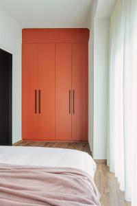 a bedroom with red cabinets and a white bed at HOME OF THE SOUL in Ioannina