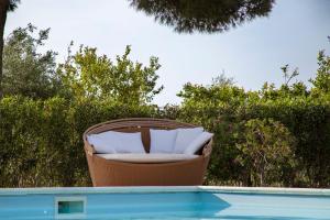 una sedia in vimini seduta accanto alla piscina di B&B Villa Seta a Agrigento