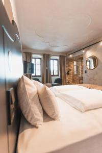 a hotel room with a large bed with pillows at H5 Grauer Bär Studios & More in Innsbruck