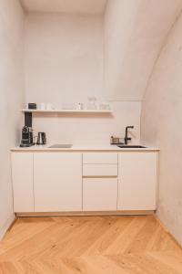 a kitchen with white cabinets and a sink at H5 Grauer Bär Studios & More in Innsbruck