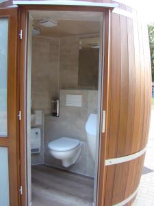a bathroom with a toilet and a glass door at Schlaffass bei Meyerhöms in Hermannsburg