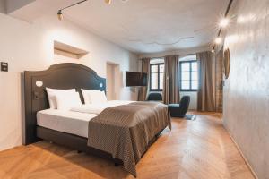 a hotel room with a bed and a tv at H5 Grauer Bär Studios & More in Innsbruck