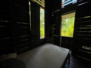 a bedroom with a bed in a room with a window at Peaceland Hostel in Panglao Island