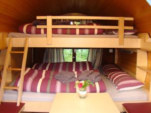 2 łóżka piętrowe w pokoju ze stołem w obiekcie Schlaffass bei Meyerhöms w mieście Hermannsburg