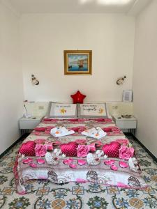 una camera da letto con un letto con rose rosa di Casa Tutti Frutti a Positano