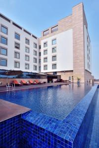 a swimming pool in front of a building at Courtyard by Marriott Raipur in Raipur