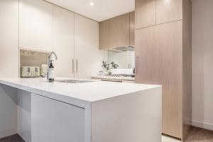 a kitchen with white cabinets and a white counter top at Your Gateway to Sports and Entertainment-00215 in Melbourne