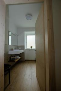 ein Bad mit einem Waschbecken und einer Tür zu einem Zimmer in der Unterkunft Casa Carolina in Levico Terme