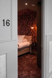 1 dormitorio con cama y pared con pared en The Yard hotel Noordkade en Veghel