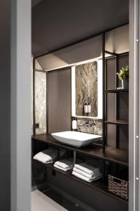 baño con lavabo y encimera con toallas en The Yard hotel Noordkade en Veghel