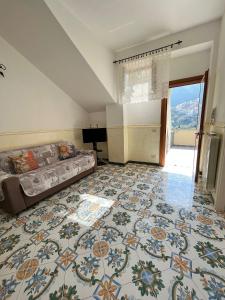 a living room with a bed and a large tile floor at Casa Tutti Frutti in Positano