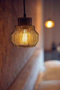 a yellow pendant light hanging over a bed at The Yard hotel Noordkade in Veghel