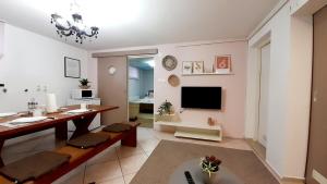 a living room with a dining table and a television at Apartment Eleco in Bjelovar