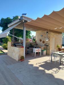 eine Terrasse mit einer Außenküche mit einem Sonnenschirm in der Unterkunft Casa Oliva 52 in Sevilla