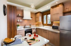 une cuisine avec une table et un réfrigérateur dans l'établissement Muses Beach Villas - Cleo, à Siteía 7 autres photos