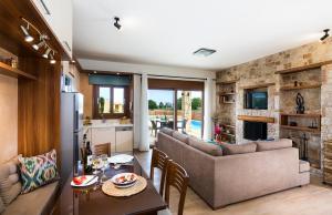 une cuisine et un salon avec un canapé et une table dans l'établissement Muses Beach Villas - Erato, à Siteía