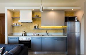 una cucina con armadi blu e frigorifero in acciaio inossidabile di Muses Beach Villas - Thalia a Sitia