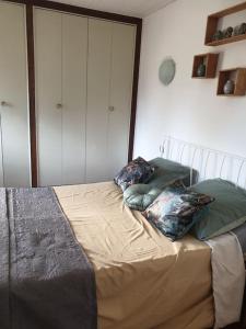 1 cama con 3 almohadas en un dormitorio en Appartement, prive terrasse, parking et jardin, en Le Boulou