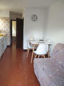 a living room with a table and chairs and a kitchen at Appartement, prive terrasse, parking et jardin in Le Boulou