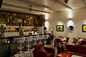a restaurant with a bar with white chairs and tables at Su Hotel - Bodrum in Bodrum City