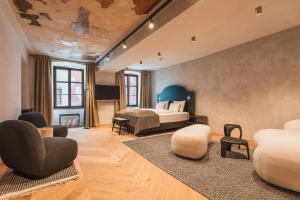 ein Schlafzimmer mit einem Bett und Stühlen in einem Zimmer in der Unterkunft H5 Grauer Bär Studios & More in Innsbruck