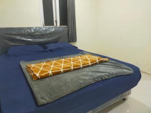 Una cama con una manta encima. en Bromo Semesta Guesthouse en Probolinggo