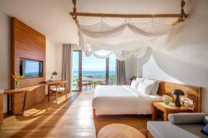 a hotel room with a bed and a desk and a television at Ana Mandara Cam Ranh in Cam Ranh