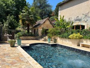 a swimming pool in front of a house at Domaine de Beaufort in Saint-Front-de-Pradoux