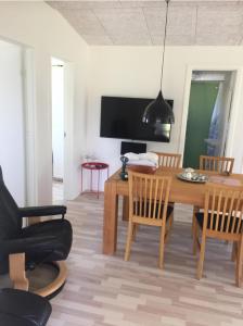 salon z drewnianym stołem i krzesłami w obiekcie Mersted Holiday House w mieście Tønder