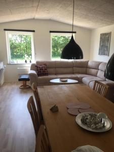 ein Wohnzimmer mit einem Sofa und einem Tisch in der Unterkunft Mersted Holiday House in Tønder