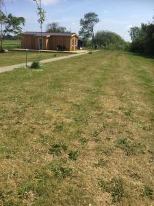 a field of grass with a house in the background at Mersted Holiday House in Tønder