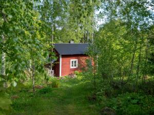 una cabaña roja en medio de un bosque en Koskivaara - vanha koulu - old school en Huutotöyry