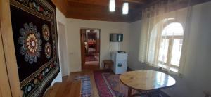 a small room with a table and a table and a window at Ethno Guest House Caravan Tamchy in Tamchy