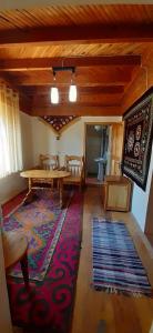 a living room with a wooden table and a rug at Ethno Guest House Caravan Tamchy in Tamchy