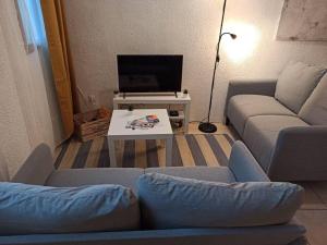 sala de estar con sofá y TV en Chez Mylène et J-P en Orange