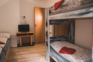 a bedroom with two bunk beds and a television at Chata - Sklep 57 in Starovice