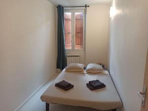 um pequeno quarto com uma cama com duas toalhas em Chez Mylène et J-P em Orange